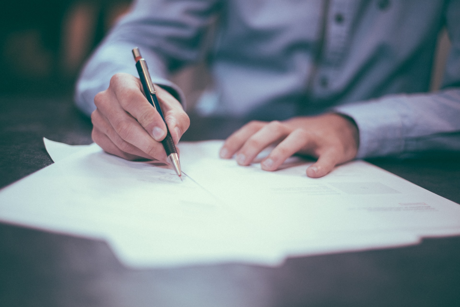 A man signing a contract representing an employer owing a dismissed employee their bonus entitlements