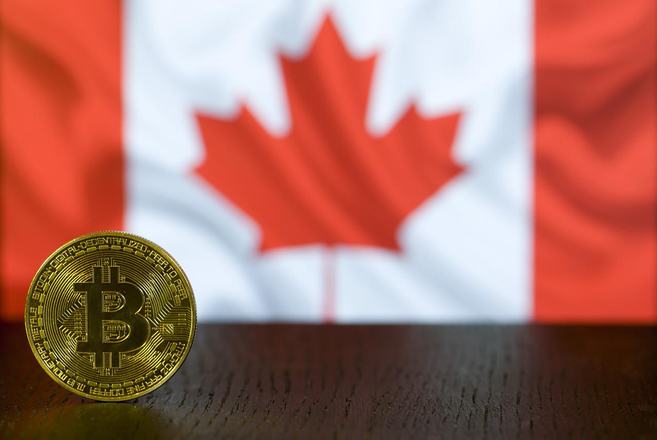 a gold bitcoin in the foreground with a Canadian flag in the background, representing Canadian cryptocurrency taxes
