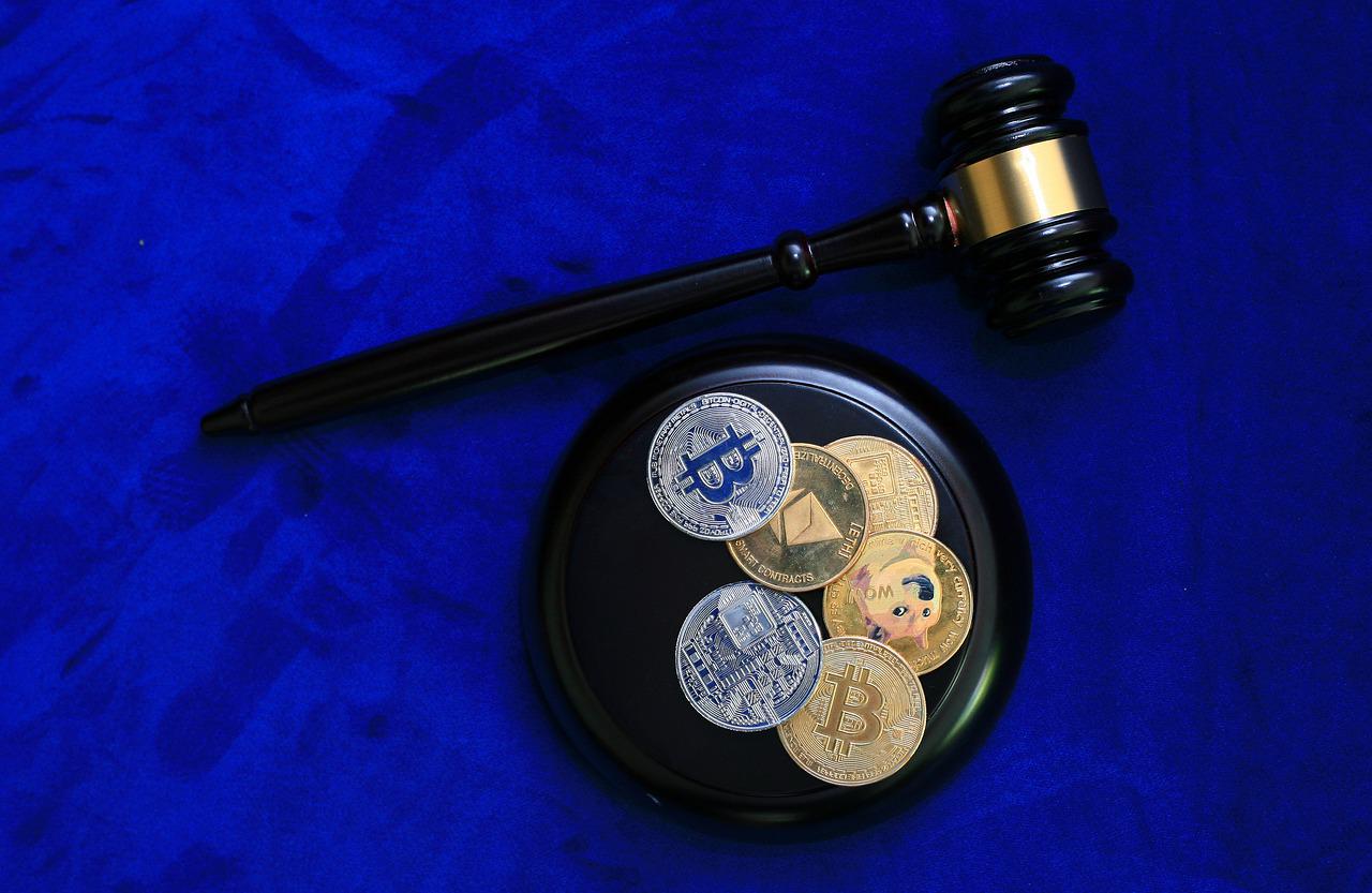 cryptocurrency coins on a disc next to a judge's gavel, representing cryptocurrency regulation