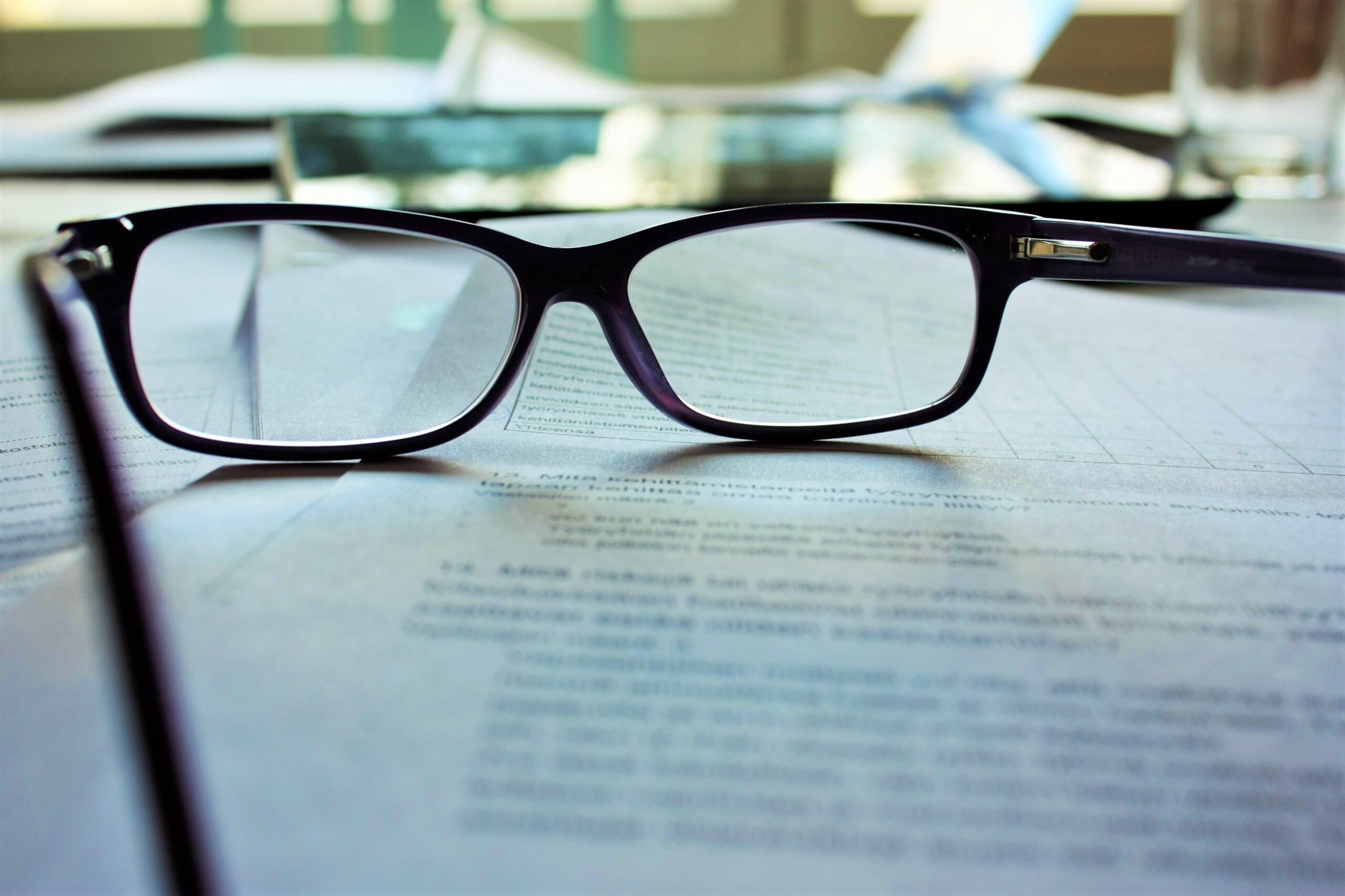 Reading glasses on top of a document representing individual liability in the acts of a corporation.
